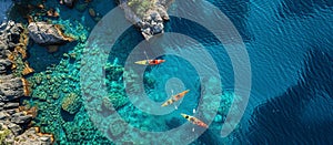 Aerial view of people kayaking in clear blue waters, summer adventure in beautiful seascape