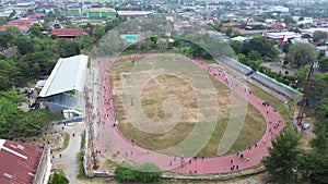 Aerial view of people running at the GOR Nani Wartabone, Gorontalo City. Group of people on the running track