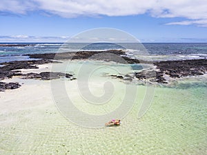 Aerial view of people in summer holiday vacation with beautiful girl on coloured trendy lilo relaxing and sunbathing on clear