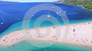 Aerial view of people sunbathing on a sandy beach on the island of Brac, Croatia