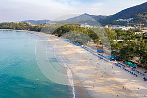 Aerial view of people swimming in the transparent turquoise sea at Karon beach in Phuket, Thailand