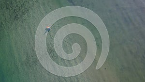 Aerial view of a person on a paddle boat in Ballynamona beach in county Cork, Ireland