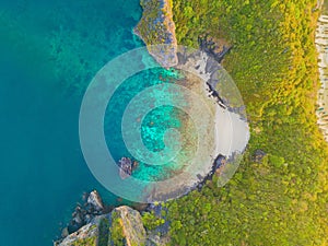 Aerial view of Phi Phi, Maya beach with blue turquoise seawater, mountain hills, and tropical green forest trees at sunset with