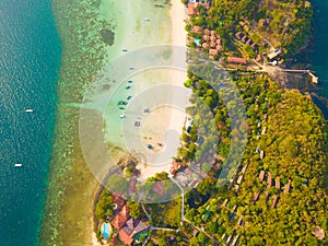 Aerial view of Phi Phi, Maya beach with blue turquoise seawater, mountain hills, and tropical green forest trees at sunset with