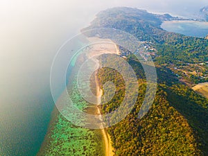 Aerial view of Phi Phi, Maya beach with blue turquoise seawater, mountain hills, and tropical green forest trees at sunset with