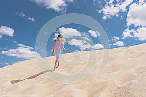 Aerial view photo - a lonely girl walks on the sandy desert.