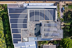 Aerial view of photovoltaic solar panels or solar cells installed at rooftop of factory building