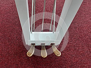 Aerial view of piano pedals. Three piano levers to create musical effects. Close up of Sustain, soft and sostenuto pedal. Parts of