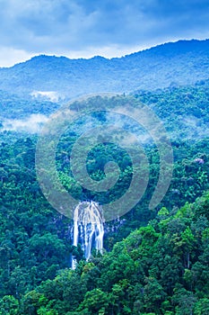 Aerial view of picturesque waterfall in blue mist