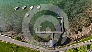 Aerial view of a pier with pedalos and boats. Annecy lake, France