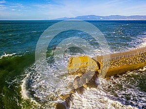 Aerial view of a pier with rocks. Pizzo Calabro pier, panoramic view from above. Broken pier, force of the sea. Power of Waves. N