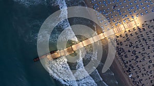 Aerial view of pier, with the waves and the mainland