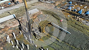 Aerial view of a pile driver rig at construction site and crane at sunny day