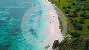 Aerial view of Pink Beach with green color on the hill and turquoise sea from Komodo Island Labuan Bajo