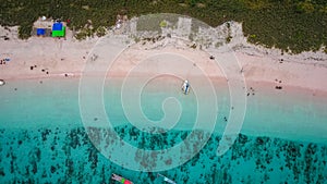 Aerial view of Pink Beach with green color on the hill and turquoise sea from Komodo Island Labuan Bajo