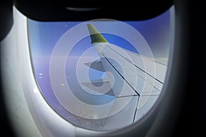 Aerial view from plane window with airplane wing and Andean mountain range below