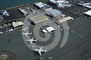 Aerial view of planes, helicopters, and cars parked by buildings