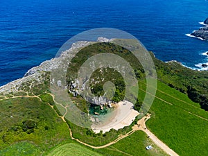 Aerial view, Playa de Gulpiyuri, flooded sinkhole with inland beach near Llanes, in Asturias Northern Spain, around 100 m from