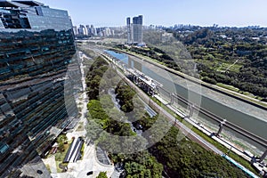 Aerial view of the polluted Pinheiros River next to expressways and modern buildings. Sao Paulo, Brazil