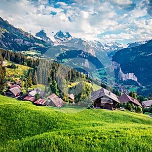 Aerial view of popular tourist destination - Wengen village. Fgesh green grass pasture in Swiss Alps, Bernese Oberland in the cant