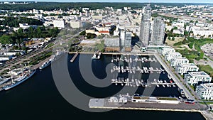 Aerial view of port full of white yachts and sailboats in a modern seaside city.