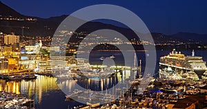 Aerial view of port Hercules in Monaco - Monte-Carlo at dusk, a lot of yachts and boats are moored in marina, cityscape