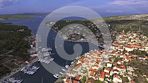 Aerial view of port in Milna, Croatia, drone view point, a full rainbow on the horizon, islands, is parked yachts