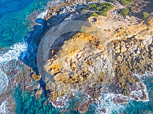 Aerial view of Porto Ferro tower surrounded by blue water