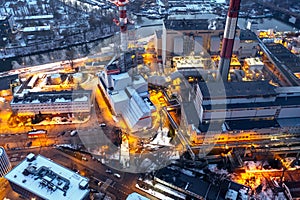 Aerial view of the power plant. View of the chimneys, cooling tower and buildings in the evening. Brightly lit industrial