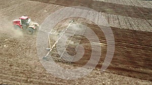 Aerial view of a powerful energy-saturated tractor with a large hook force, performing tillage for sowing winter crops