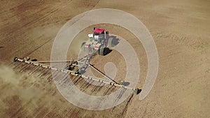 Aerial view of a powerful energy-saturated tractor with a large hook force, performing tillage for sowing winter crops