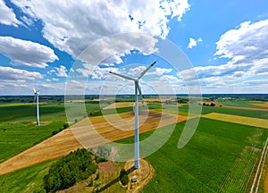 Aerial view of powerful Wind turbine farm for energy production on beautiful cloudy sky at highland. Wind power turbines