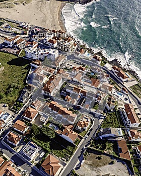 Aerial view of Praia das Macas little township from top, view of the red rooftop of a small town along Portuguese shoreline, photo