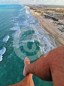 Aerial View of Praia do Futuro Beach, Fortaleza, CearÃÂ¡ Brazil from a paraglider flight, legs showing.. photo