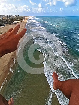 Aerial View of Praia do Futuro Beach, Fortaleza, CearÃÂ¡ Brazil from a paraglider flight. Hand and legs. photo