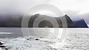 Aerial view of pristine nature.Video of waves break on rocks cliffs. Aerial view of ocean waves breaking on the rocky