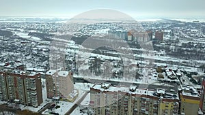 Aerial view of private houses residential area and high residential buildings in winter city.