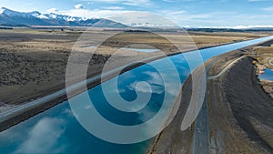 Aerial view of the Pukaki hydro power scheme canal near Twizel running in parallel with the snow capped Ben Ohau mountain range