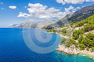 Aerial view of Punta Rata beach with boats and azure sea in Brela, Croatia, Dalmatia, Croatian azure coast