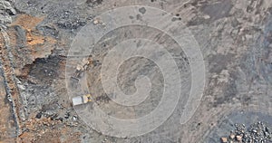 Aerial view in a quarry, excavator and dump truck during the loading of mined rock.