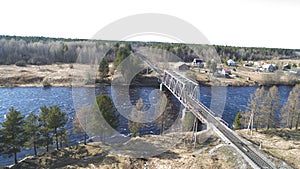 Aerial view on the rail bridge across the river in rural place in spring