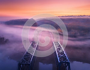Aerial view of railroad bridge in fog at sunrise in autumn