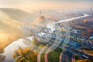 Aerial view of railroad bridge and river in fog at sunrise