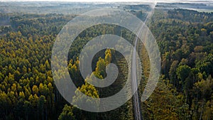 Aerial view of railroad in forest at foggy autumn morning