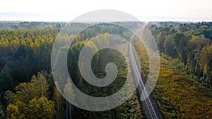 Aerial view of railroad in forest at foggy autumn morning