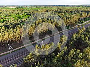 Aerial view of railroad in sunny summer day in forest. Top view of Logistics, trade, shipping ways.