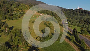 Aerial view of a railroad the train leaves the tunnel in summer mountains with lush green forest.