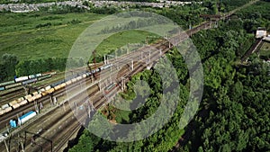 Aerial view of railway station in countryside. Bird's eye view of railroad station with freight trains in summertime.