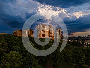 Aerial view on rain clouds at sunset over the city