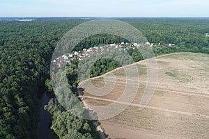 Aerial view of Real estate community `Ozerki`, Desna river valley, and ploughed land from the birds sight, Podolsk region, Russia